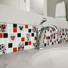 a bathroom sink with mickey mouse tiles on it