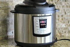 an electric pressure cooker sitting on top of a counter next to a brick wall