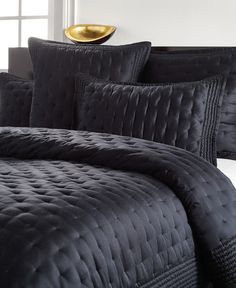 a black comforter and pillows in a room