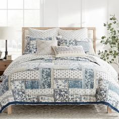 a blue and white quilted bed with pillows