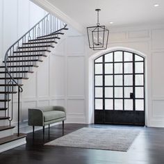 an elegant entryway with stairs and chairs