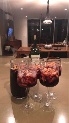 three glasses filled with liquid sitting on top of a table