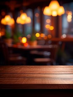 an empty wooden table top in front of a blurry restaurant with lights on the windows