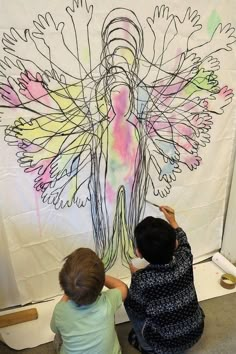 two children are drawing on a wall