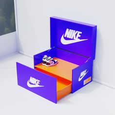 a pair of nike shoes sitting inside of a purple and orange shoe box next to a window