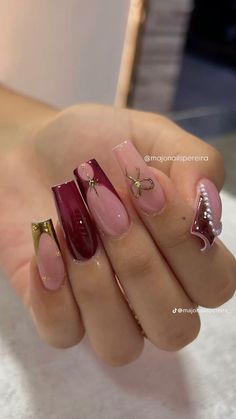 a woman's hand with some pink and gold nail polishes on her nails