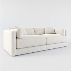 a white couch with pillows sitting on top of it