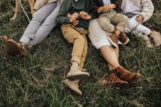 three adults and two children sitting on the grass with a dog in the back ground