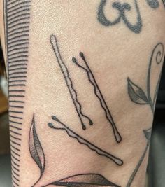 a close up of a person's leg with tattoos on it and an arrow