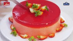 a red cake on a white plate with a knife sticking out of it's top