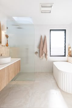 a bathroom with a large tub, sink and window in it's center area