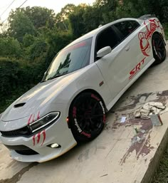 a white car parked on top of a cement slab