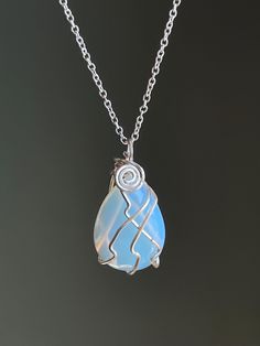 a necklace with a piece of glass in the shape of a heart on a chain