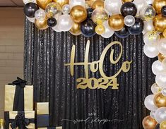 a black and gold celebration with balloons, presents and gifts on the floor in front of a backdrop that says holo 2013