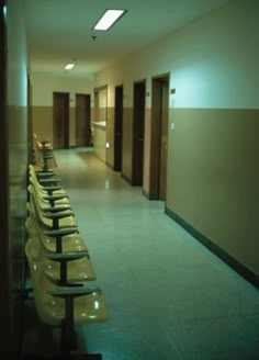 a long row of chairs sitting in a hallway next to a wall with lights on it