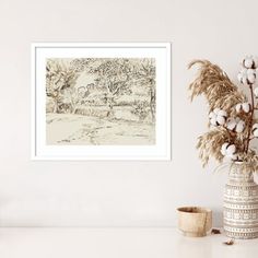 a vase filled with cotton flowers next to a painting on the side of a wall