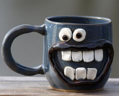 a coffee mug with googly eyes and teeth