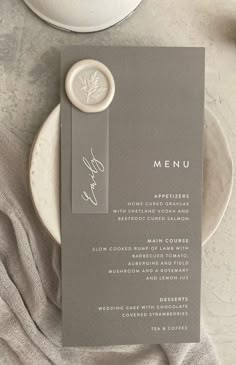 a table setting with plates, silverware and napkins on it that include a menu