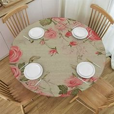 the table is set with white plates and place settings for four people to sit at