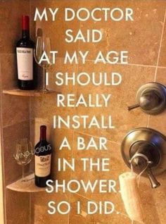 a wine bottle is sitting on the shelf next to a shower faucet and soap dispenser