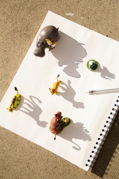 an elephant, giraffe, and other toy animals on top of a sheet of paper