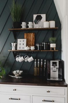 a coffee maker and some cups on a shelf