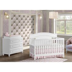 a baby's room with a crib, dresser and bed in white color