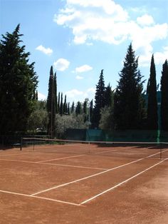 a tennis court with trees in the background