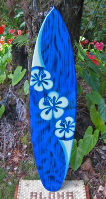 a blue and white surfboard sitting on top of a wooden stand in the grass