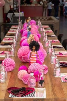 a long table with pink decorations and barbie dolls on it