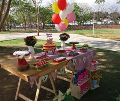 a table topped with lots of desserts and balloons