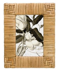 a bamboo frame with white flowers and leaves on the inside, in front of a white background