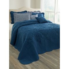 a bed with blue comforter and pillows on it