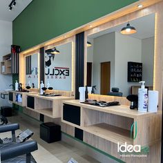 the interior of a barber shop with large mirrors and lights on each side of the counter