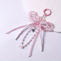 a pink and white beaded keychain with a star on the side, attached to a string