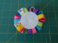 several colorful hair clips sitting on top of a green cutting board next to a ruler