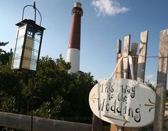 a sign that says this way to get married next to a light house