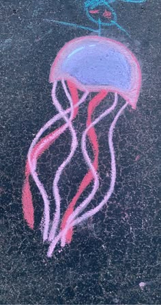 a chalk drawing of a jellyfish on the ground with pink and blue crayons