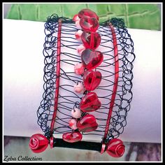 a close up of a bracelet on a person's arm with red glass beads