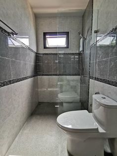 a bathroom with a toilet, sink and shower stall in the middle of the room