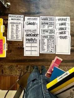 a person's feet on a table with some books and pencils