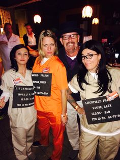 three women and two men holding signs in front of them at a bar or restaurant