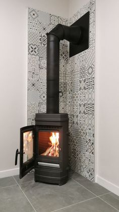 a small stove in the corner of a room next to a wallpapered wall