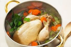 a pot filled with chicken, carrots and celery