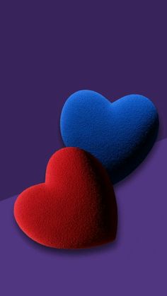 two blue and red heart shaped sponges on top of each other in front of a purple background