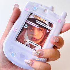 a person holding up a cell phone with pictures on the screen and stars around it