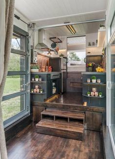 the interior of a mobile home with stairs leading up to the kitchen and living room