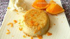 an orange dessert with whipped cream and orange slices on a white plate next to it