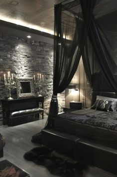 a bedroom with stone walls and flooring has a black canopy bed in the middle