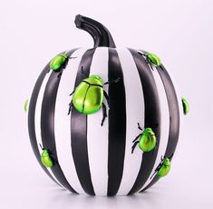 a black and white striped pumpkin with green apples on it